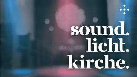 Verschwommene schwarz weiß Aufnahme des Altarraums mit roten und blauen Lichtstrahlern und der Aufschrift "Sound. Licht. Kirche."